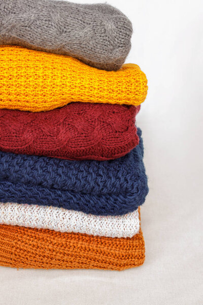 Stack of knitted colorful warm sweaters