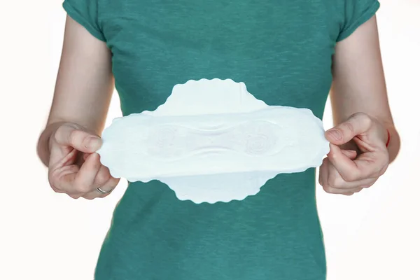 Close-up of young woman holding sanitary pad over white background — Stok Foto
