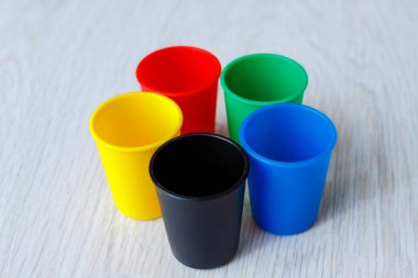 Ahşap beyaz arka plan üzerinde renkli plastik kapaklar