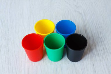 Ahşap beyaz arka plan üzerinde renkli plastik kapaklar