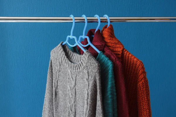 Теплі вовняні светри, що звисають на вішаках — стокове фото