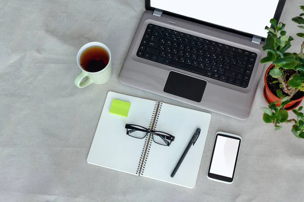 Komfort pracy widok z góry. Projektant biurko z pusty ekran, notebook, laptop, telefon i filiżanki herbaty — Zdjęcie stockowe