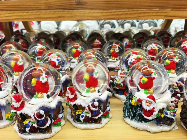 Muito brinquedo de Natal de vidro, lembrança - bola de neve em prateleiras — Fotografia de Stock