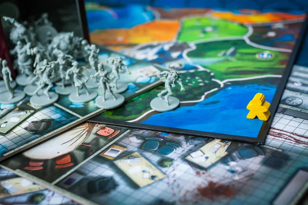 Brettspielkonzept - viele Brettspielfelder, Meeple-Figuren laufen Zombi-Figuren davon — Stockfoto