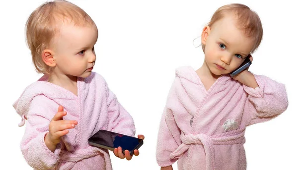 Zweijähriges kleines Mädchen mit einem Smartphone auf weißem Hintergrund — Stockfoto