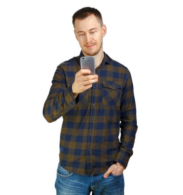 genç adam Kareli gömlekli bir cep telefonu, rahat kıyafetler, beyaz arka plan üzerinde izole kullanır