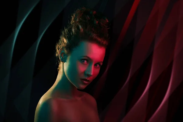 Портрет милой рыжей головы девушки с вьющимися волосами в красочных ярких огнях позирует в студии — стоковое фото