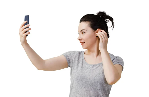 Bilden av ung asiatisk kvinna står isolerade över mörka grå vägg bakgrund tittar åt sidan gör selfie av smartphone. — Stockfoto