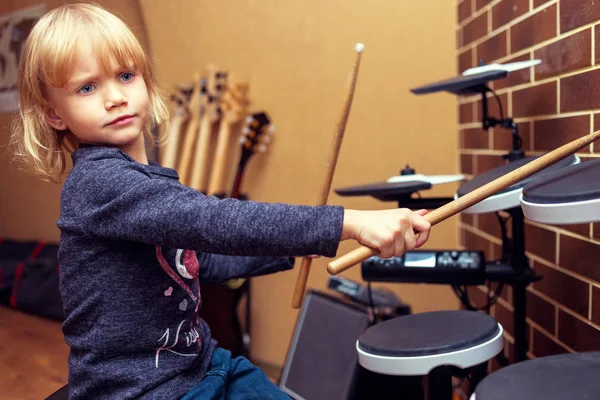 Un piccolo batterista caucasico che suona la batteria elettronica. La ragazza impara a suonare la batteria a scuola di musica. Ritratto emotivo — Foto Stock