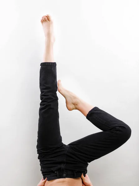 Jeans femme jambes démonstration sans chaussures, studio tir sur fond gris gros plan — Photo