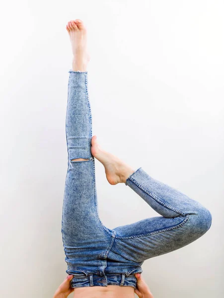 Jeans femme jambes démonstration sans chaussures, studio tir sur fond gris gros plan — Photo