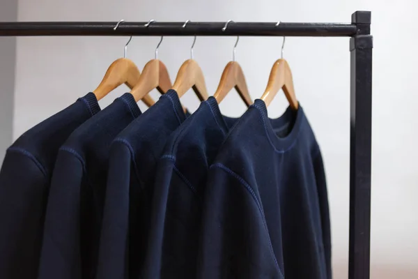 Puste bluzy wiszące na wieszaku w szafie lub salonie — Zdjęcie stockowe