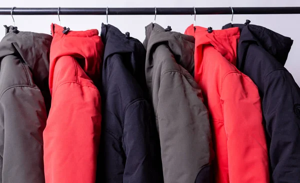 Familj koncept eller showroom av dunjacka vinter parka hängande på en hängare i garderoben — Stockfoto