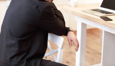 Evdeki siyah gömlekli adam. Evde oturup düşünceli bir şekilde bakmak. Yazdırma için model