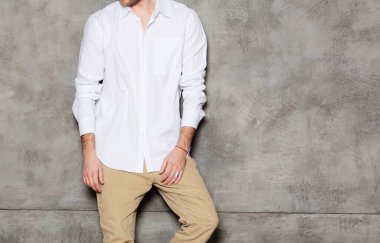 Beyaz gömlekli adam. Evdeki duvarın yanındaki merdivenlerde duruyor. Yazdırma için model