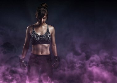 Fotokopi alanı ile spor dövüş konsepti. Siyah boks eldivenli, gri spor sutyenli ve mor dumanlı kadın portresi.