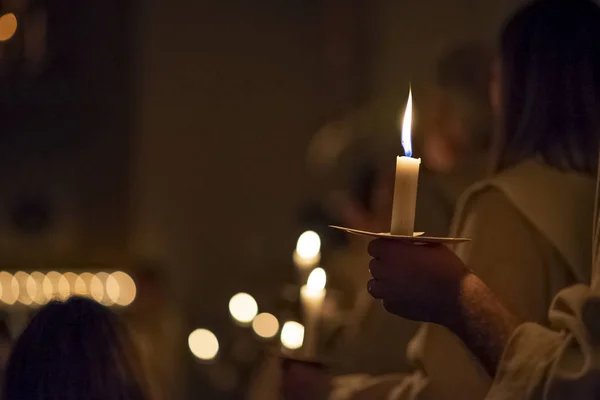 La gente está manejando velas en la tradicióntodos los vestidos de hábito religioso en la iglesia. Celebración del Día de Lucía, Suecia — Foto de Stock