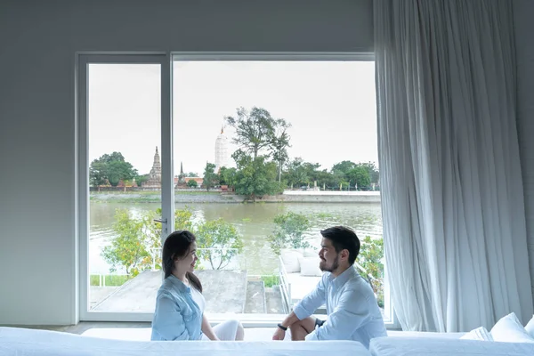 Coppia seduta e cercando l'un l'altro al divano letto nel loro nuovo appartamento con fantastica vista sul fiume / casa in movimento / obiettivo relazione — Foto Stock