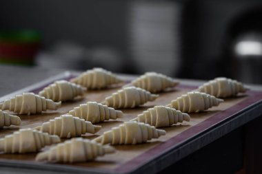 Pişirme / kopyalama konsepti / kopyalama alanından önce çiğ yumurta üzerine boyanmış çiğ kruvasan hazırlama