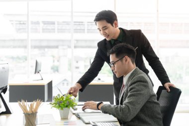 Yardımsever erkek patron akıl hocası öğretmen genç erkek stajyer öğrenciye yeni online projeyi açıklıyor, odaklanmış yönetici yönetici öğrenci eğitmeni bilgisayar ekranına işaret eden stajyer eğitmen