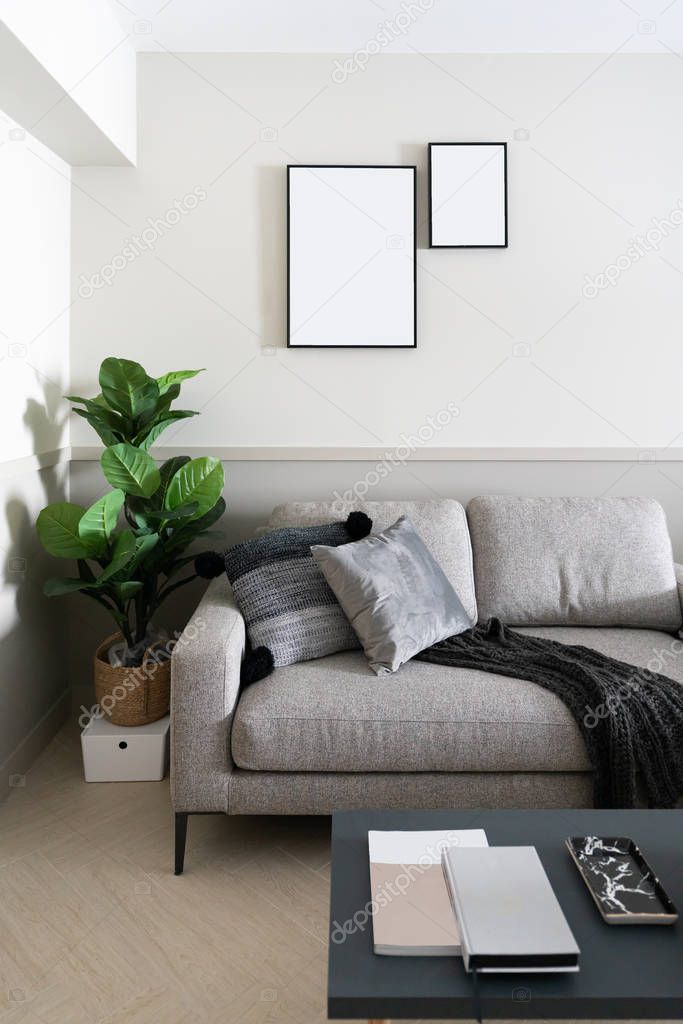 Cozy Living room corner with dark gray velvet fabric sofa , artificial plants and empty picture frame installing on the wall / cozy interior concept /space for advertising /scandinavian style interior