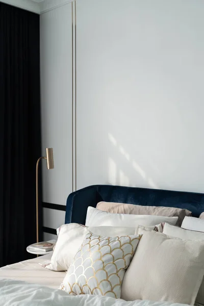 Camera da letto angolo blu navy letto di velluto con cuscini morbidi impostazione decorata con comodino circolare in marmo e vernice blu navy parete sullo sfondo / accogliente design interno — Foto Stock