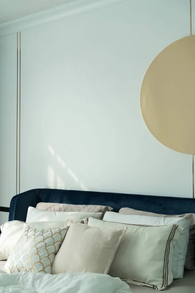 Sovrum hörna marinblå sammet säng med mjuka kuddar inställning dekorerad med guld cirkulär rostfritt och marinblå färg vägg i bakgrunden / mysig inredning — Stockfoto