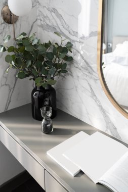 Yatak odası çalışma odası köşesi altın paslanmaz ayna ve gri sprey boyalı çalışma masasında cam vazoda yapay bitki mermer duvar arka planı / apartman içi / telif alanı ile dekore edilmiş.