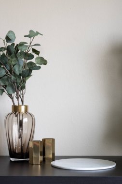 Altın paslanmaz kenarı olan cam vazodaki güzel yapay bitki ve boş siyah ahşap tepeye yerleştirilmiş altın aynalı vazo minimal modern stil daire / konut konsepti / kopyalama alanı