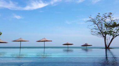 Sonsuz kenar havuzu arka planda mavi deniz ve berrak gökyüzü görüntüsü / seyahat konsepti ile tatil beldesinde