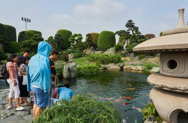 Saygon, Vietnam - 12 Aralık 2020: Saygon 'daki Rin Rin Parkı' nda Koi balıklarını besleyen bir grup insan.