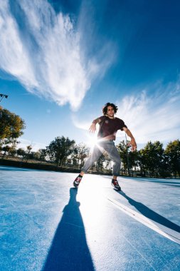 Genç adam basketbol sahasında break dans yapıyor.
