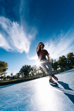 Genç çocuk dans ediyor ve basketbol sahasında poz veriyor.