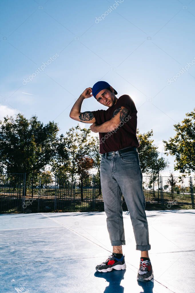 Young cool man break dancer standing in park. Tattoo on body
