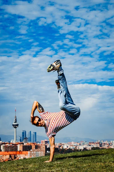 B-boy předvádí pár tahů. Breakdancer v moderním městě pozadí — Stock fotografie