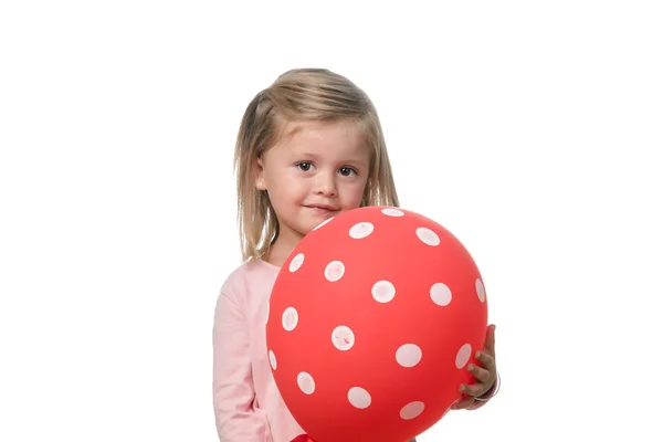 Ξανθιά κοριτσάκι χαμογελά στην κάμερα με ένα μπαλόνι σε λευκό φόντο — Φωτογραφία Αρχείου