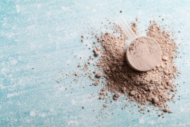 Mavi arka plan üzerinde üst görünüm peynir altı suyu protein kepçe, kopya alanı