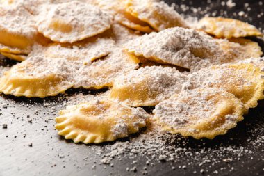 Tahta masada un ve fesleğenli çiğ ravioli.