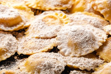 Tahta masada un ve fesleğenli çiğ ravioli.