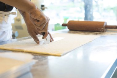 Adam mutfakta ayçöreği hamuru kesiyor. 