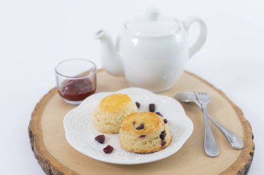 Reçelli çörekler ve masaya yakın çay, beyaz arka planda izole edilmiş.