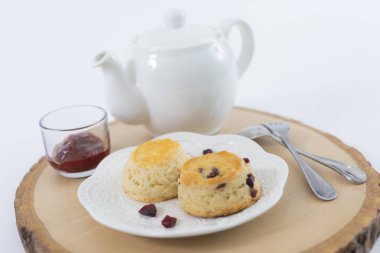 Reçelli çörekler ve masaya yakın çay, beyaz arka planda izole edilmiş.