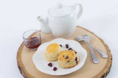 Reçelli çörekler ve masaya yakın çay, beyaz arka planda izole edilmiş.