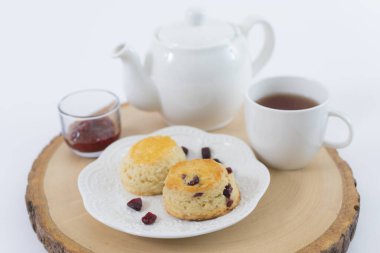 Reçelli çörekler ve masaya yakın çay, beyaz arka planda izole edilmiş.