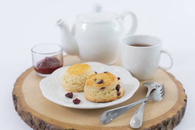 Reçelli çörekler ve masaya yakın çay, beyaz arka planda izole edilmiş.