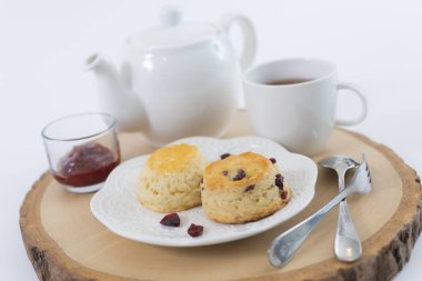 Reçelli çörekler ve masaya yakın çay, beyaz arka planda izole edilmiş.