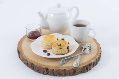 Reçelli çörekler ve masaya yakın çay, beyaz arka planda izole edilmiş.