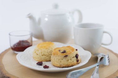 Reçelli çörekler ve masaya yakın çay, beyaz arka planda izole edilmiş.