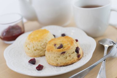 Reçelli çörekler ve masaya yakın çay, beyaz arka planda izole edilmiş.