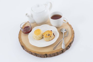 Reçelli çörekler ve masaya yakın çay, beyaz arka planda izole edilmiş.